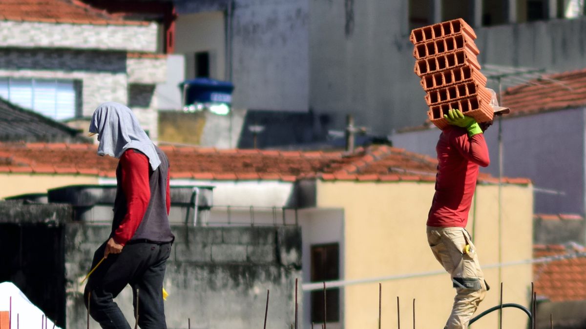 Trabalhadores em obra carregando material, ilustrando atuação em direito trabalhista na Grande Vitória